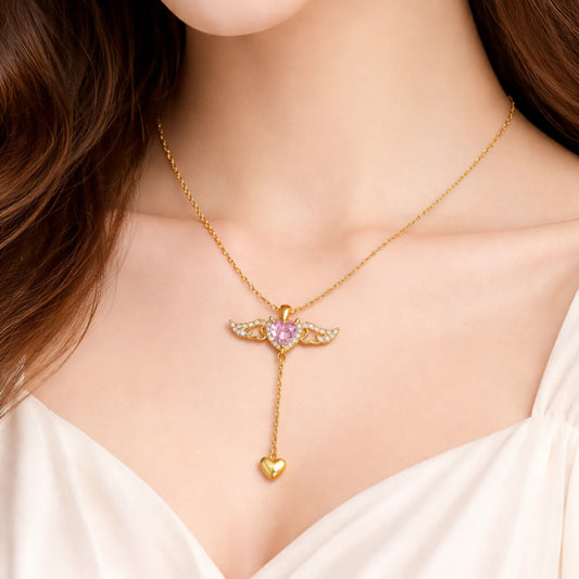 Gold necklace with a pink gemstone pendant on a model wearing a white top.