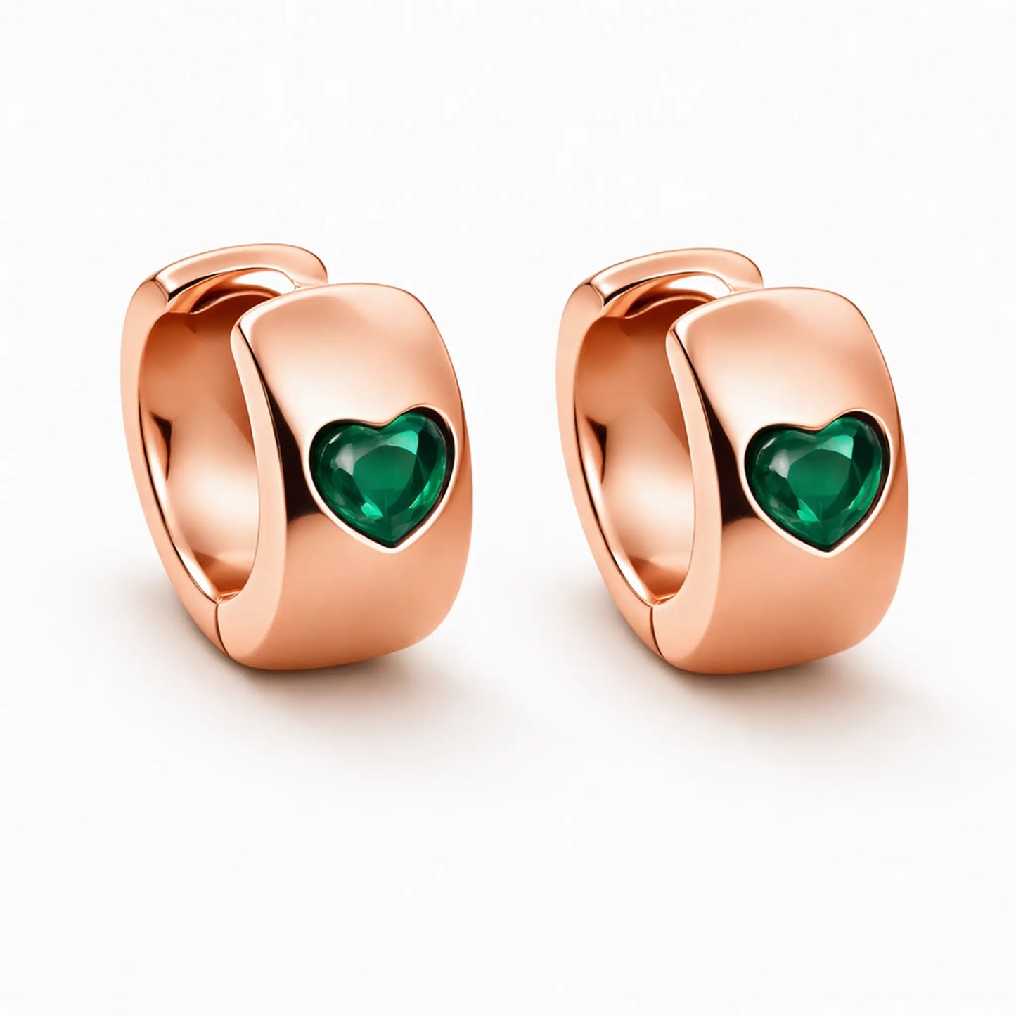 Close up of anti tarnish gold plated heart hoop earrings with green heart stone detailing