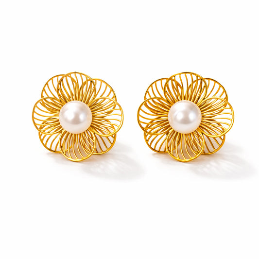 Pair of gold floral earrings with pearl centers on a white background