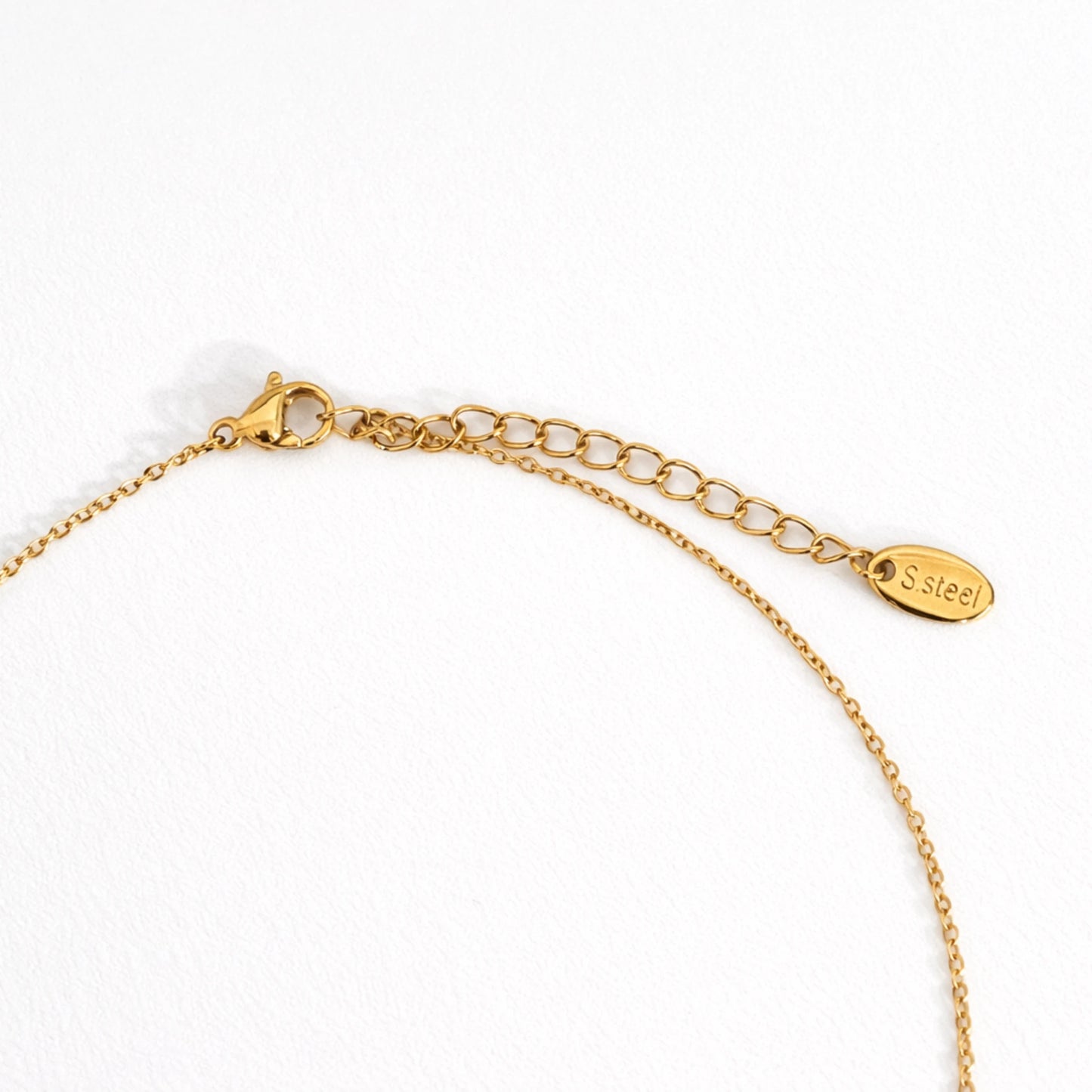 Close up of anti tarnish gold plated necklace lobster clasp with adjustable chain and stainless steel tag