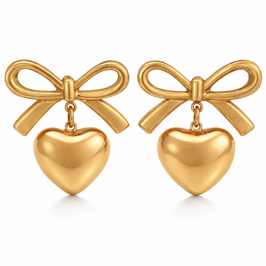 Gold bow and heart earrings on a white background