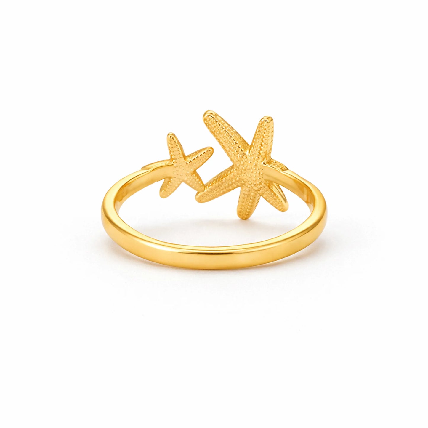 Gold adjustable starfish ring with smooth band and textured star details on white background