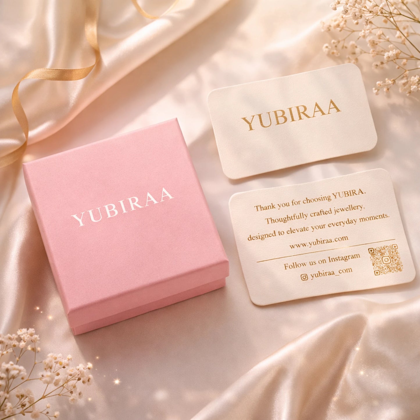 Pink jewelry box with 'YUBIRAA' branding on a white background