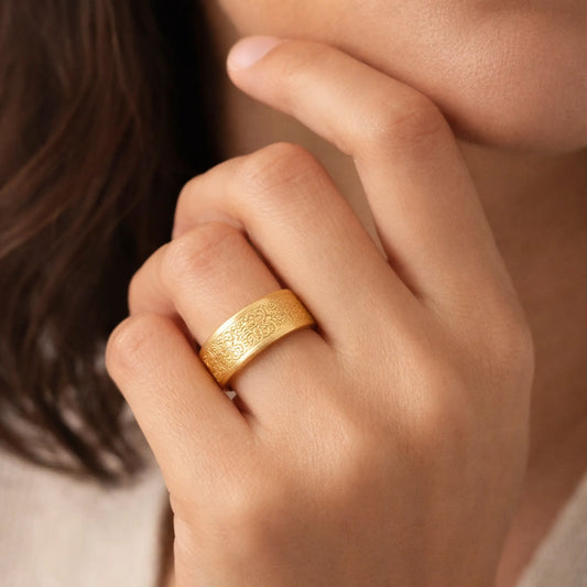 Model wearing gold textured wide band ring with hammered finish