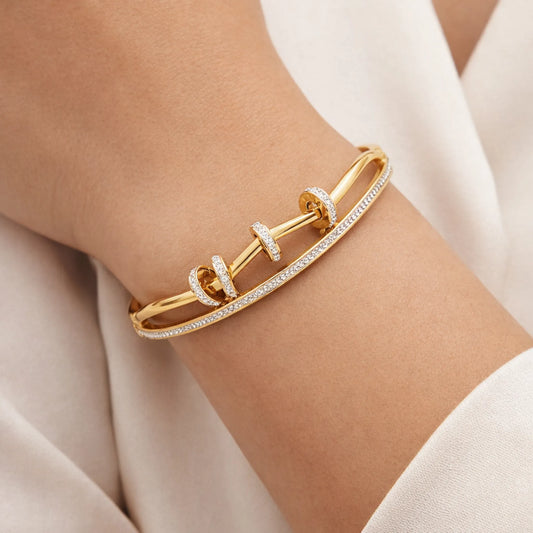 Gold bracelet with diamond accents on a wrist against a neutral background. Model wearing YUBIRAA Dual Spark Loop Gold Bracelet styled for elegant everyday wear