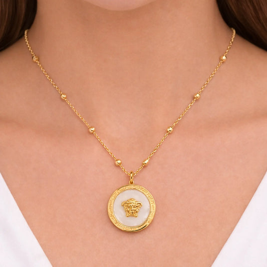“Model wearing Yubiraa anti tarnish gold plated medallion necklace with ivory stone center and evenly spaced beads, neck-only view”