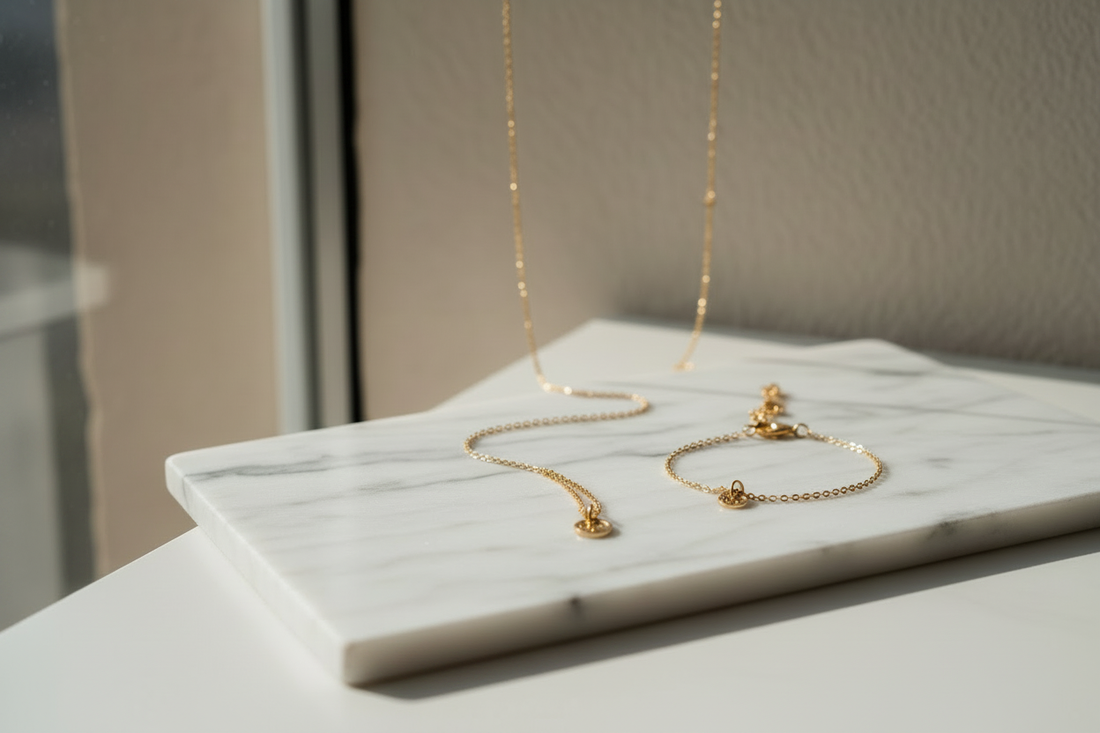 Anti-tarnish jewellery India — gold-plated necklace and bracelet on white marble, everyday jewellery for women by YUBIRAA