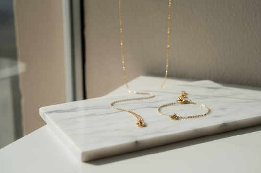 Anti-tarnish jewellery India — gold-plated necklace and bracelet on white marble, everyday jewellery for women by YUBIRAA