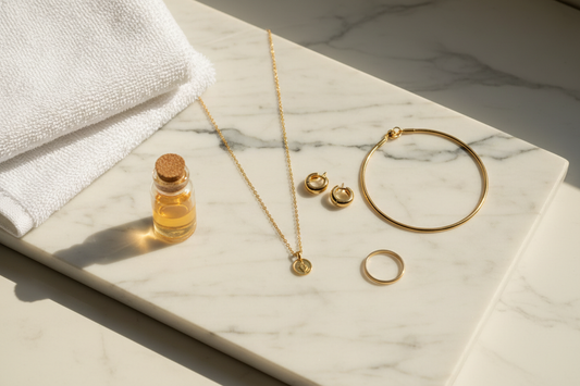 Anti-tarnish gold jewellery set placed beside a towel before showering – YUBIRAA care guide for 316L stainless steel and 18K gold PVD jewellery