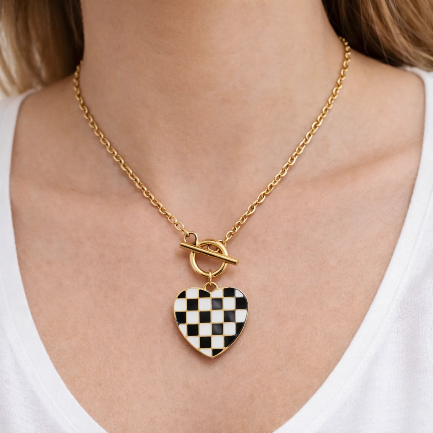 Woman wearing checkered heart pendant necklace in 18K gold plated anti tarnish stainless steel