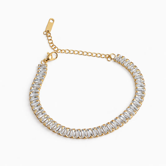 Gold bracelet with clear gemstones on a white background