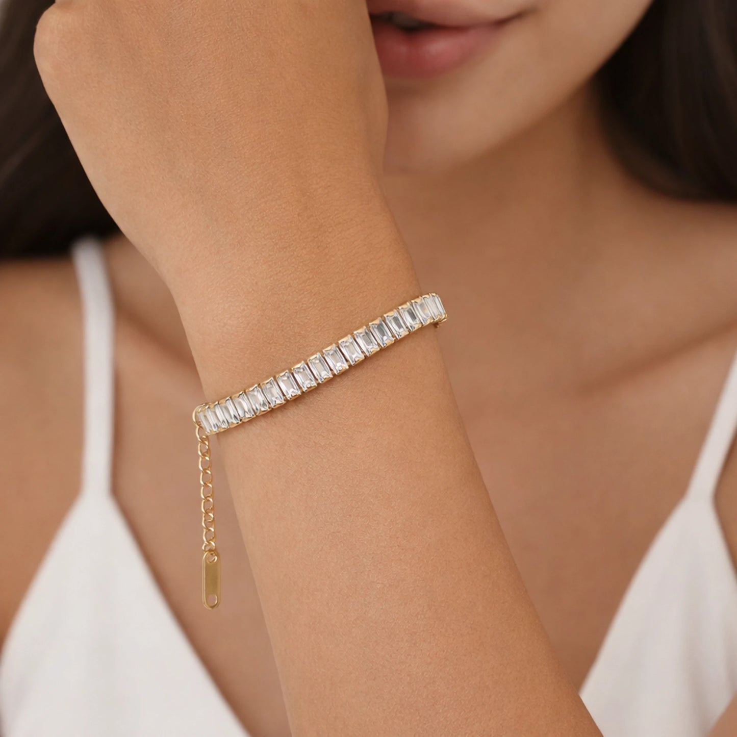 Close-up of a person wearing a diamond bracelet on a blurred background