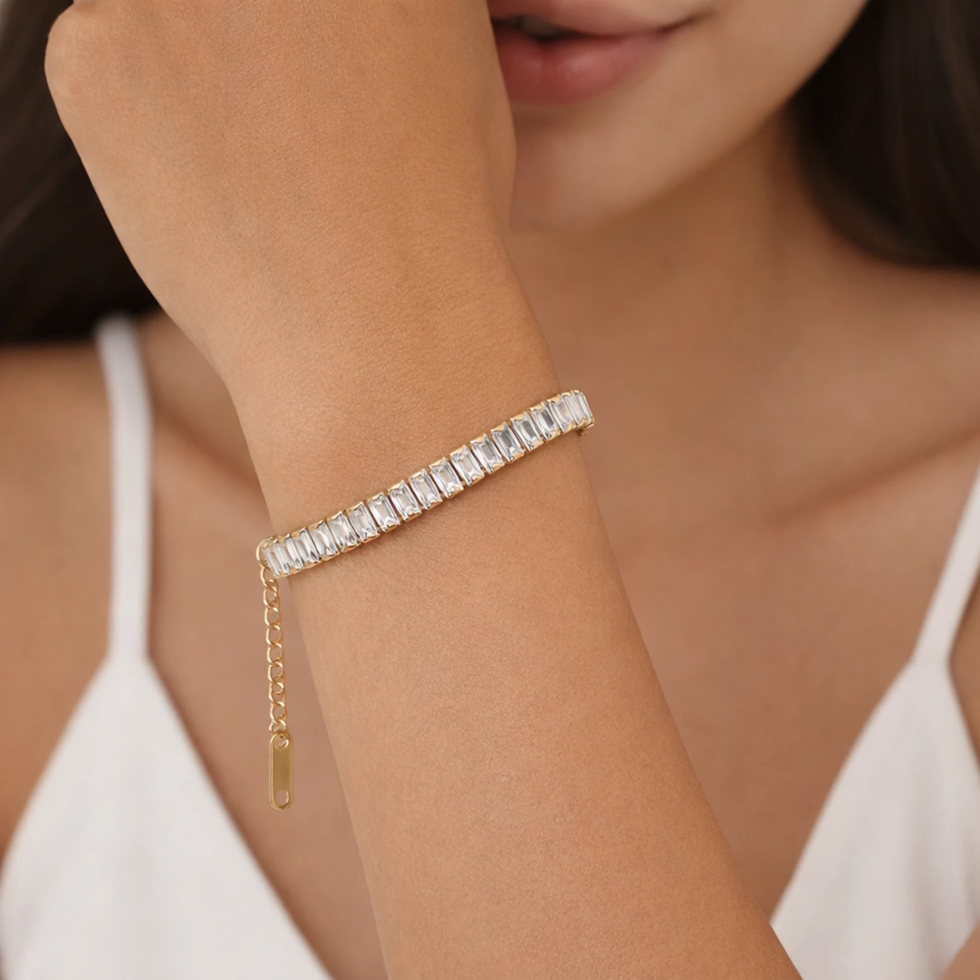 Close-up of a person wearing a diamond bracelet on a blurred background