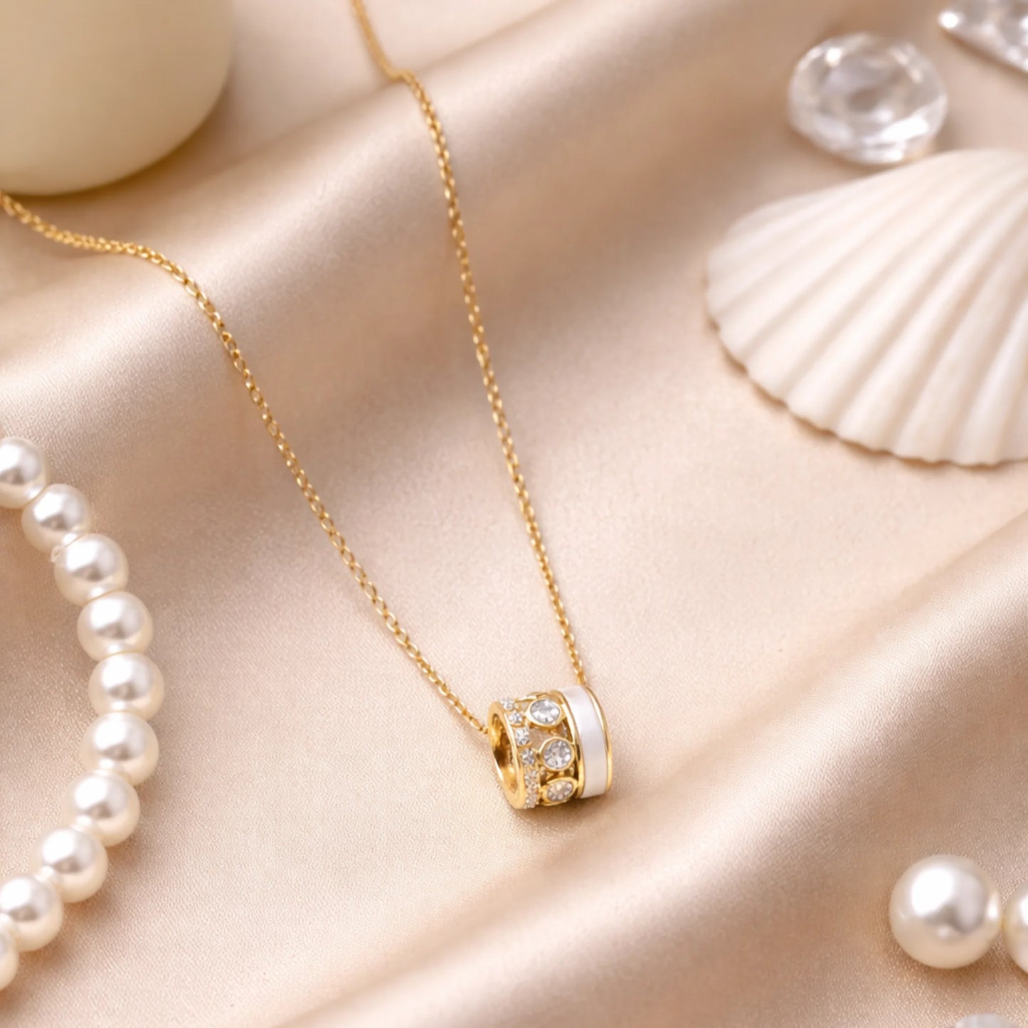 Gold necklace on a beige fabric background with pearls and shells.