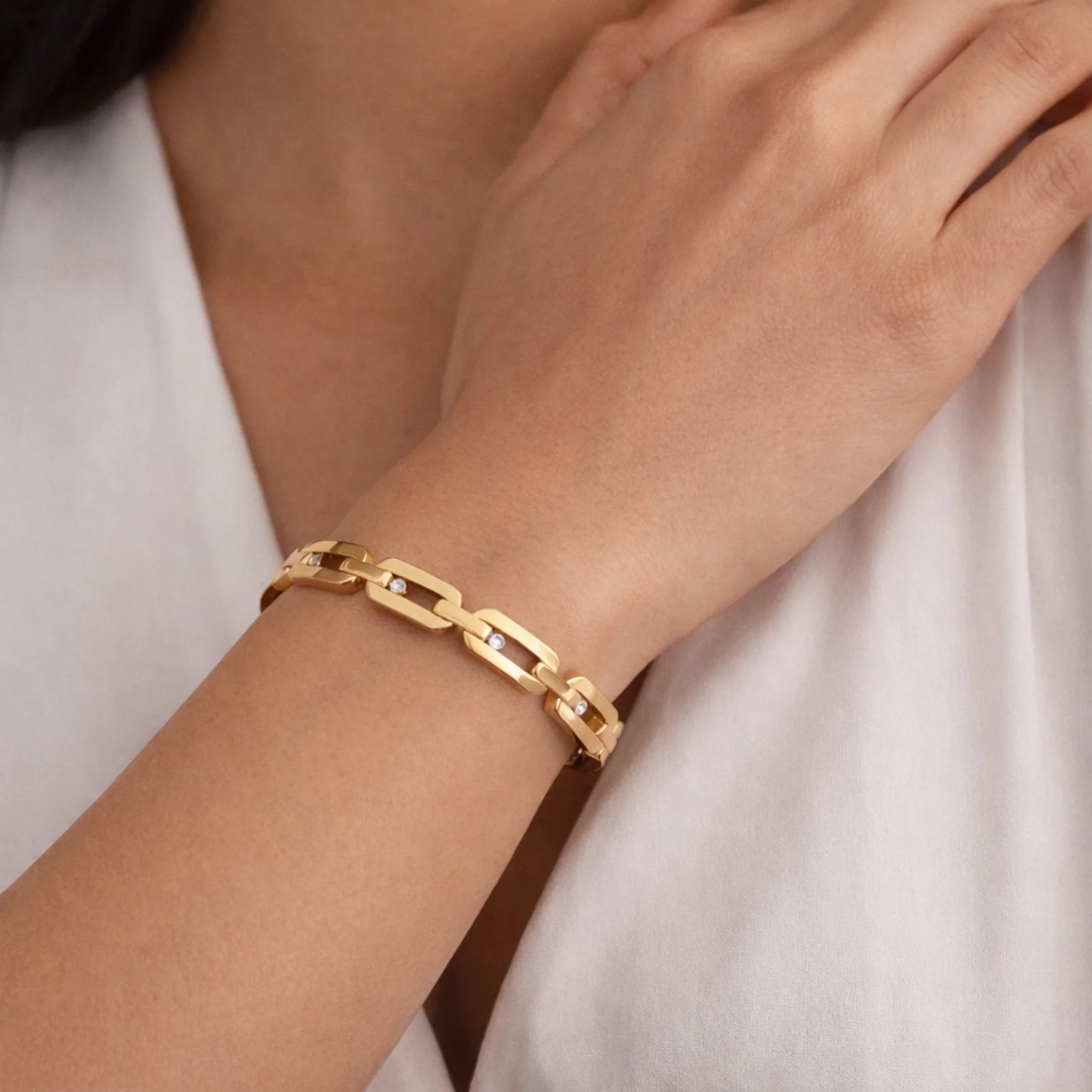 yubiraa anti tarnish classic diamond link Gold plated  bracelet on a person's wrist with a plain background