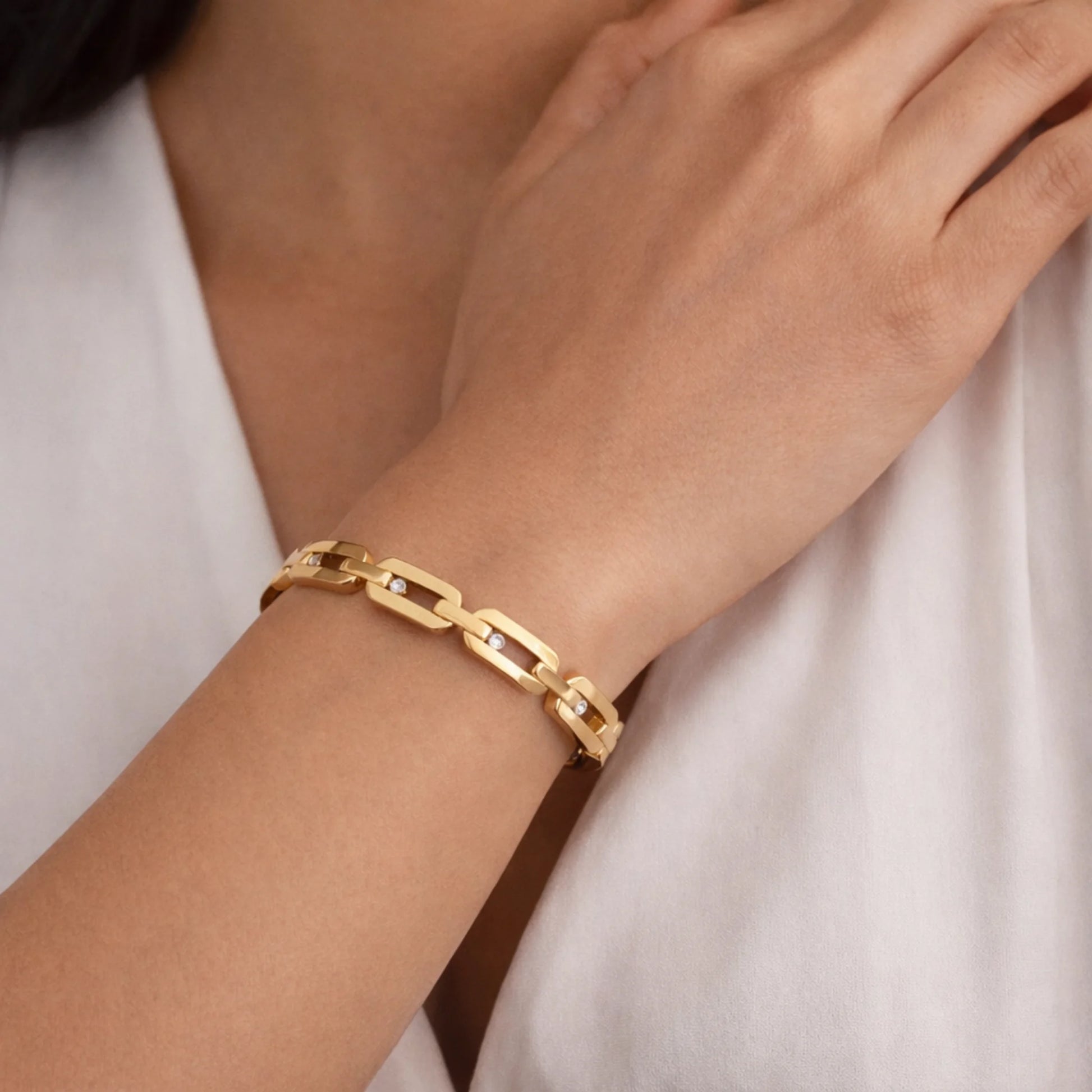 yubiraa anti tarnish classic diamond link Gold plated  bracelet on a person's wrist with a plain background