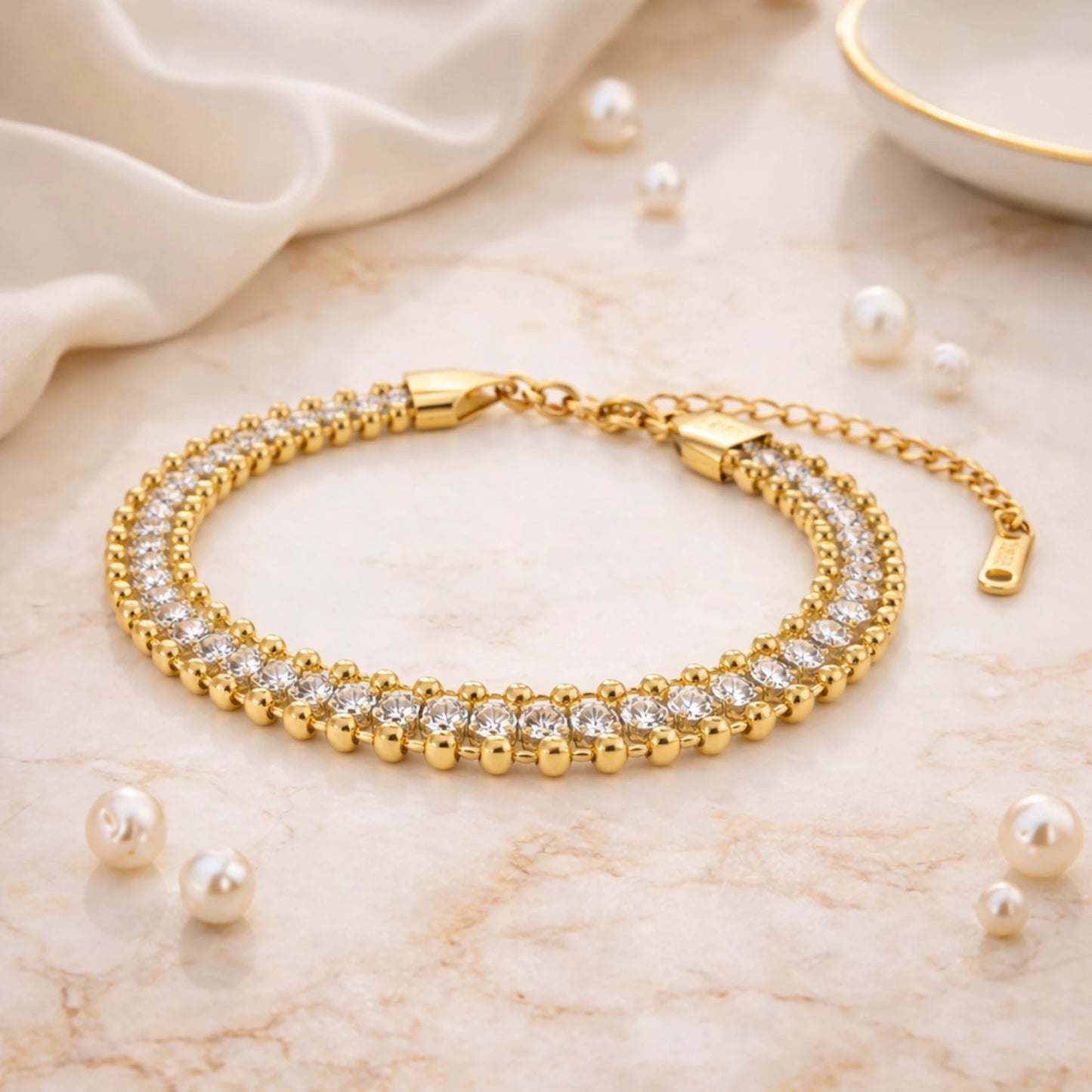 Gold bracelet with clear stones on a beige fabric background