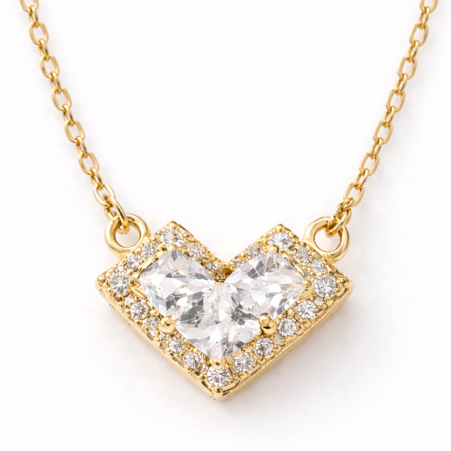 Gold necklace with a heart-shaped diamond pendant on a white background