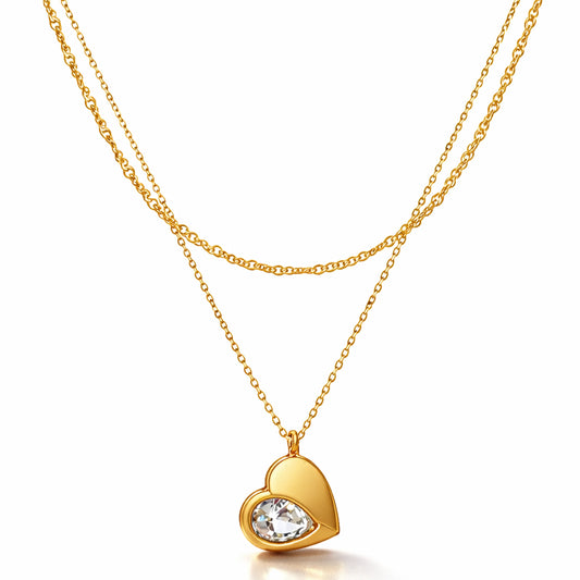 Gold heart-shaped necklace with a clear gemstone on a white background
