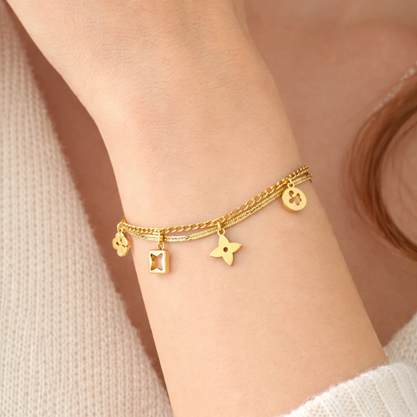 Model wearing YUBIRAA Daily Glow Charm Bracelet in gold with layered clover charm design