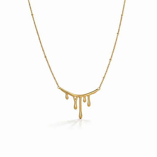 Gold necklace with a unique pendant design on a white background