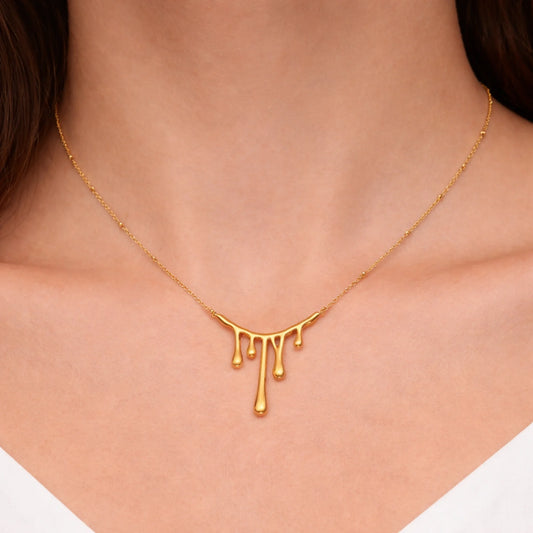 Gold necklace with a unique design worn by a person