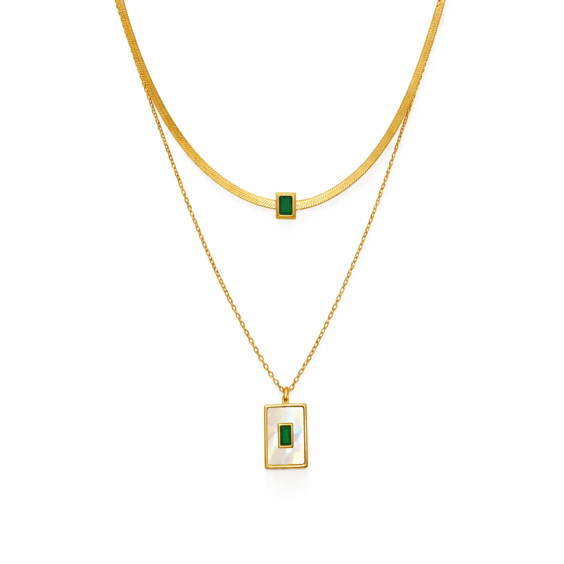 Gold layered necklace with emerald green stone pendant, cropped close-up on white background