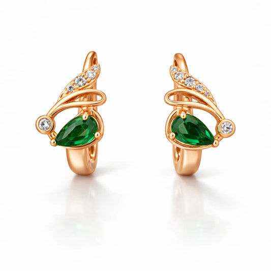 Rose gold huggie hoop earrings with pear-shaped green stone and diamond accents on white background