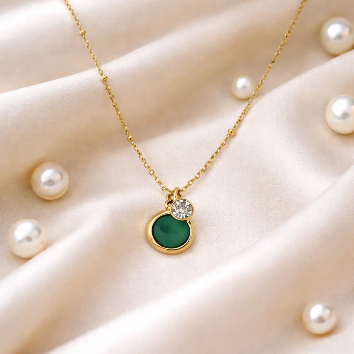 Yubiraa Anti tarnish gold plated emerald pendant necklace styled on satin background