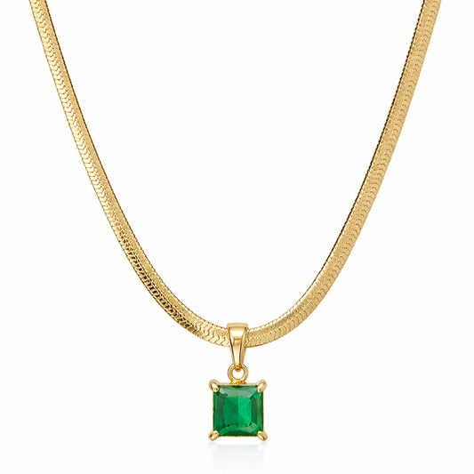 Gold necklace with a green gemstone pendant on a white background
