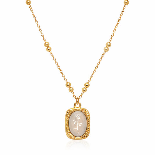 Ethereal Rose pendant necklace in gold plated stainless steel with ivory engraved rose charm on white background