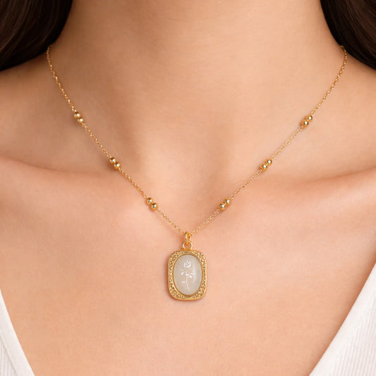 Woman wearing Ethereal Rose pendant necklace in 18K gold plated stainless steel with engraved rose design