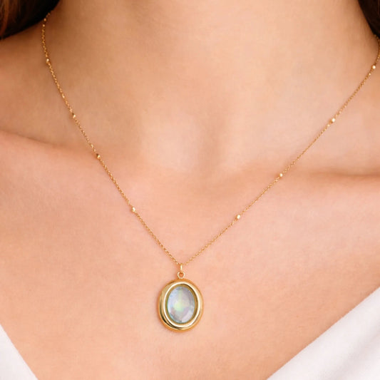 Model wearing gold oval opal pendant necklace, minimal everyday jewellery styling on neckline