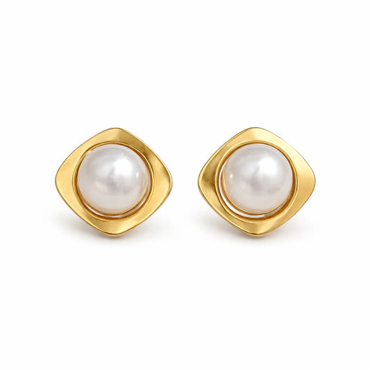 Pair of gold earrings with pearl centers on a white background