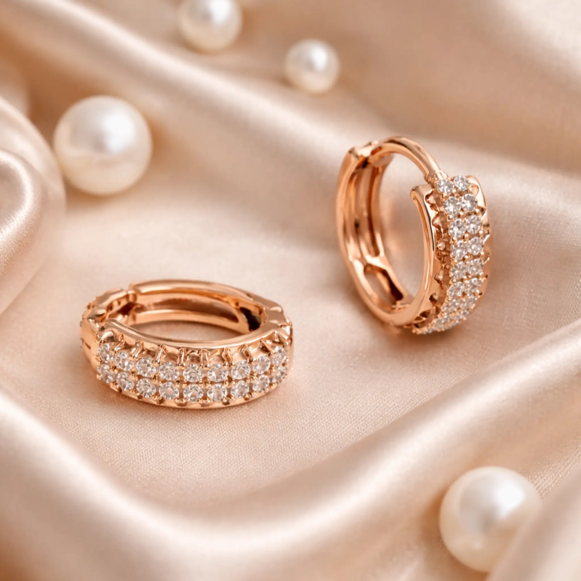 Anti-tarnish gold plated pavé hoop earrings styled on soft satin fabric with pearls for an elegant jewelry lifestyle look