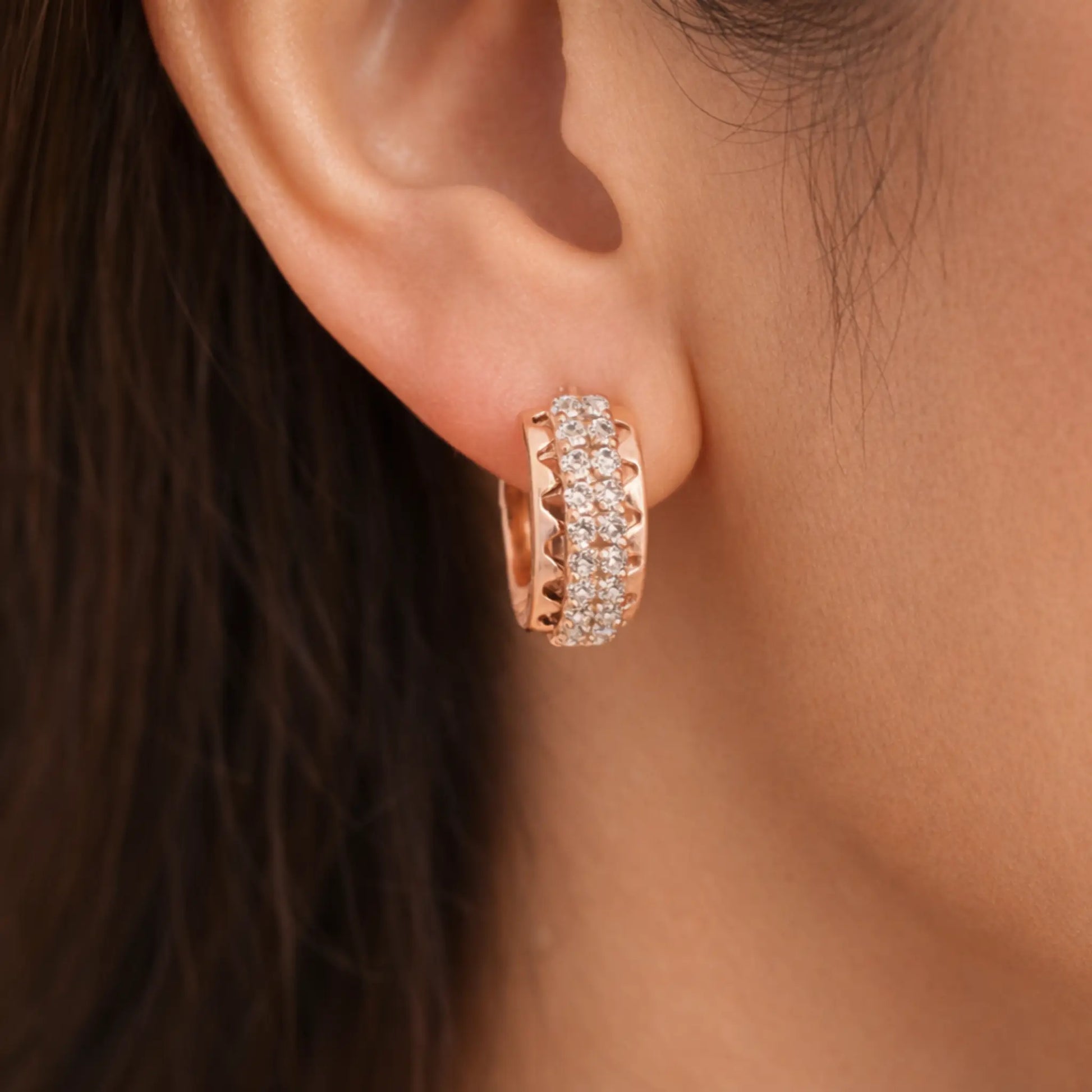 Model wearing anti-tarnish gold plated pavé hoop earrings with sparkling cubic zirconia stones