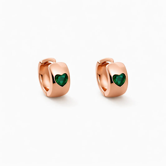Rose gold hoop earrings with green heart stones on a white background Anti tarnish gold plated heart hoop earrings featuring emerald green heart stone front view
