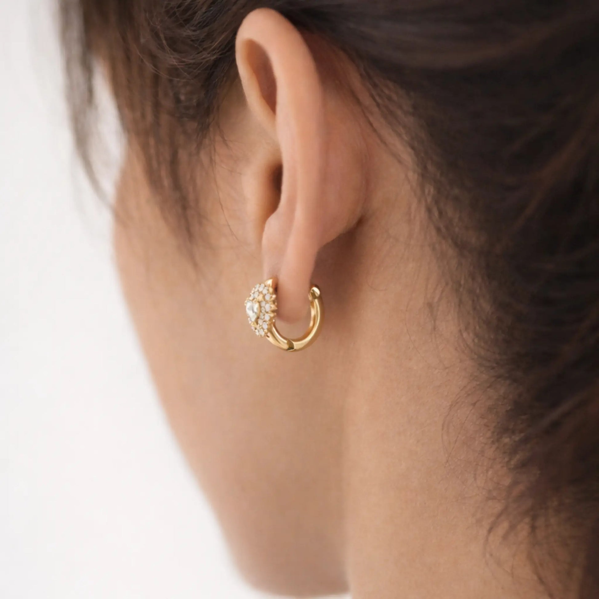 Anti tarnish gold polish heart crystal hoop earrings worn on ear showcasing secure lever back closure