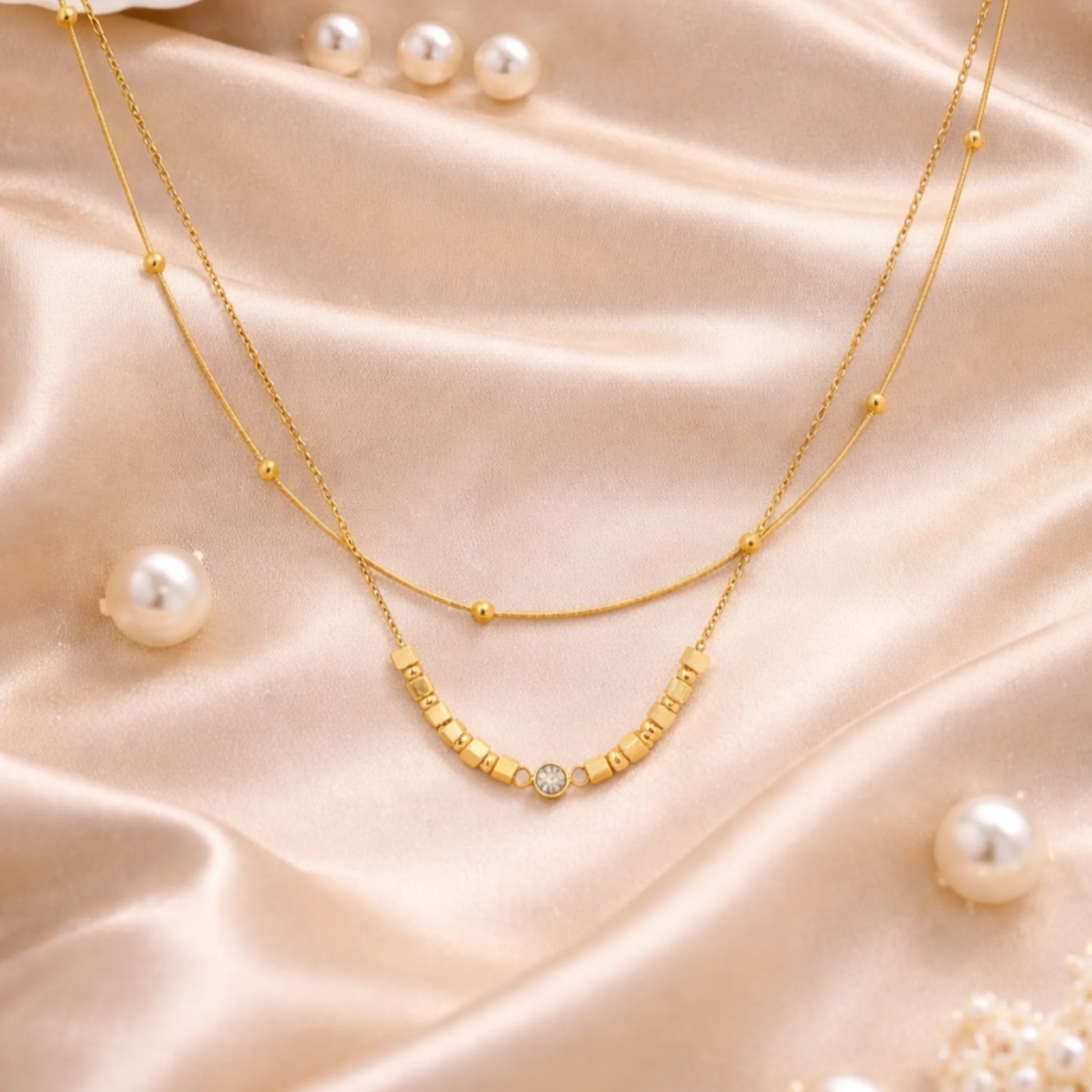 Gold necklace with pearls on a satin surface