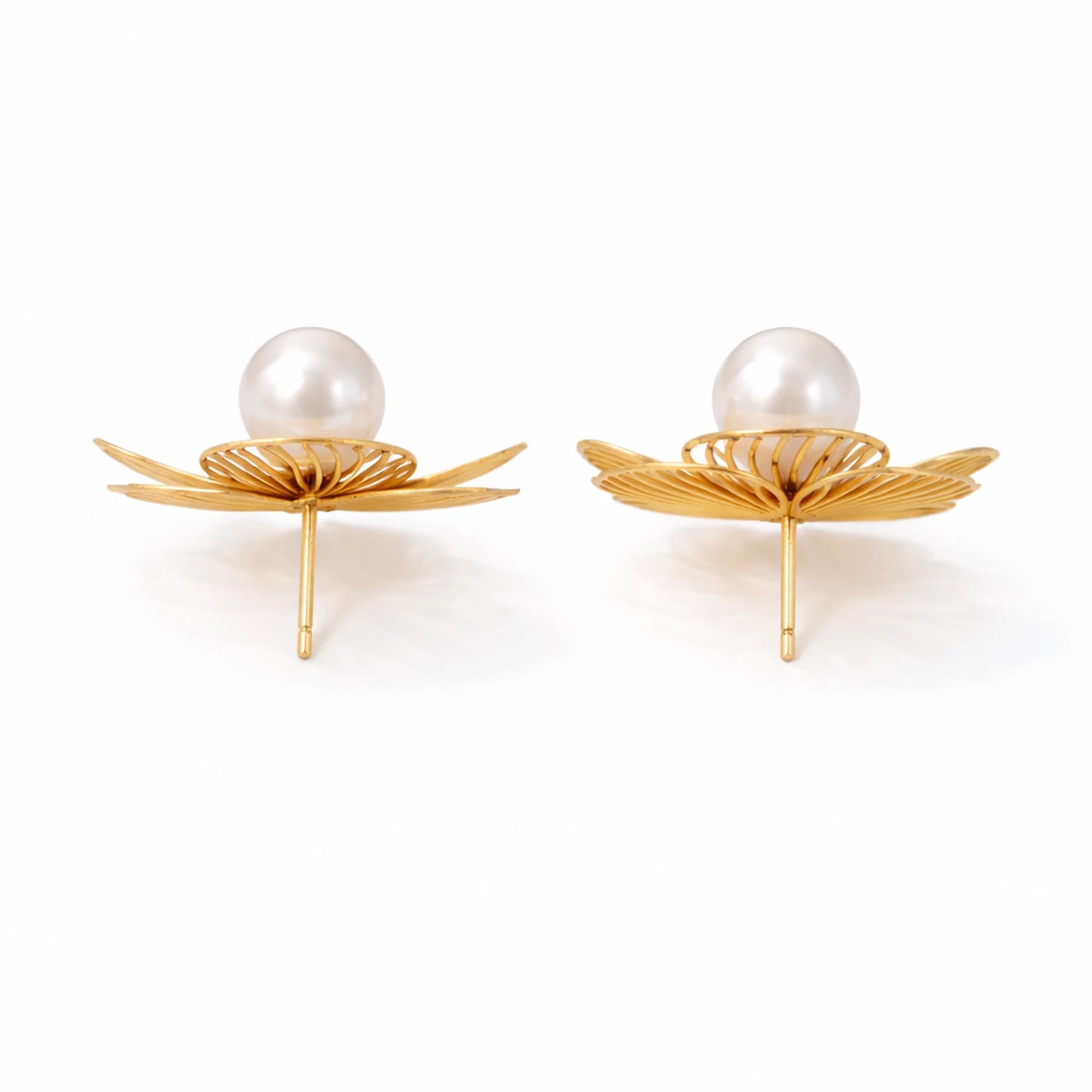 Pair of earrings with gold leaf-like designs and pearl centers on a white background