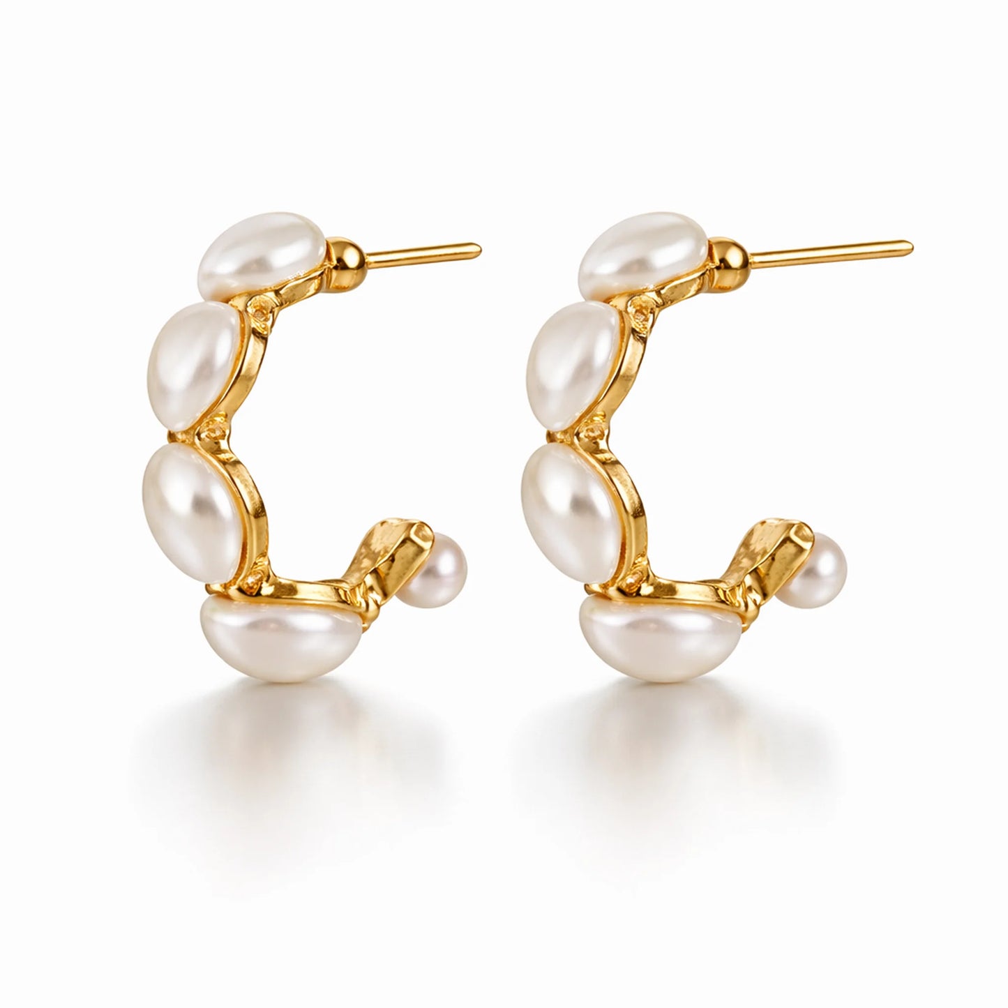 Gold hoop earrings with pearls on a white background