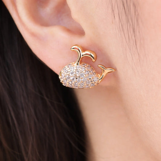 Model wearing anti-tarnish gold plated whale stud earrings with pavé cubic zirconia detailing
