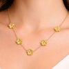 Gold necklace with floral pendants on a person's neck