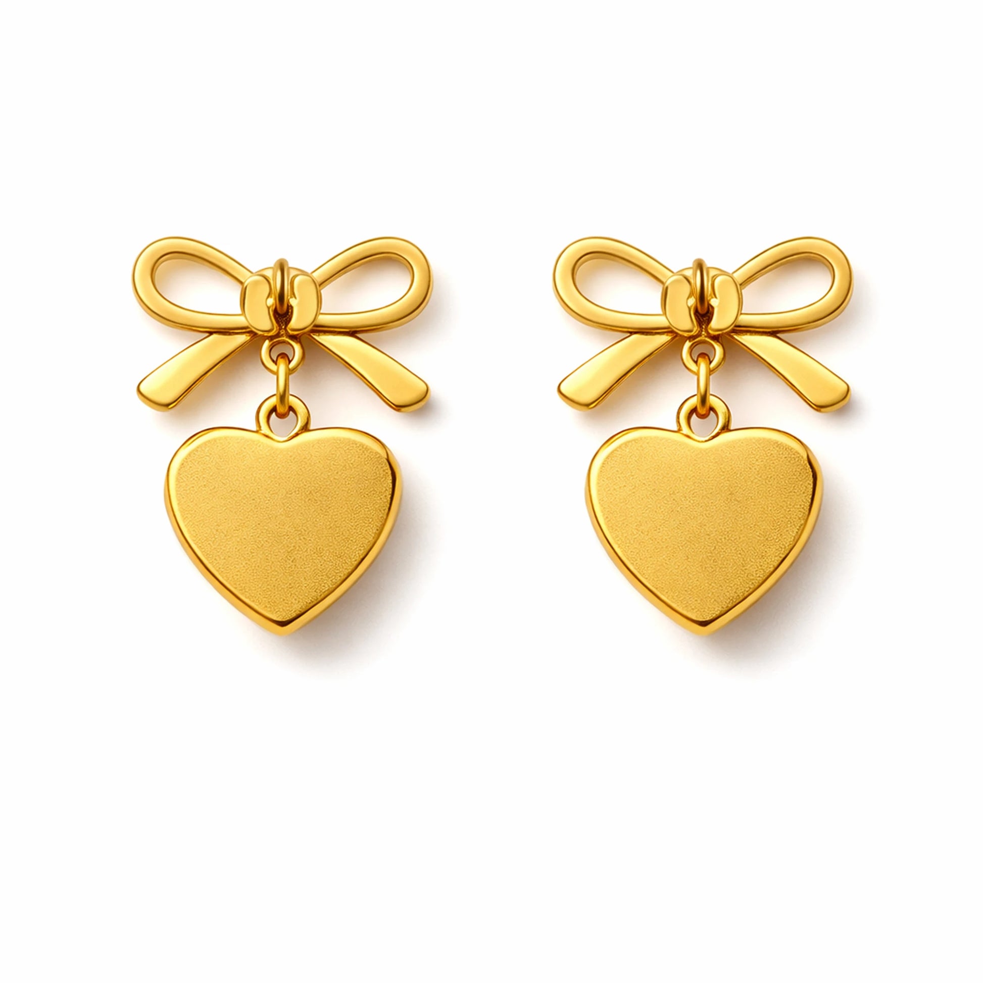Gold bow and heart earrings on a white background