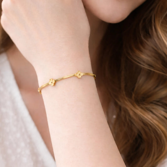 Gold bracelet on a person's wrist with a soft focus background