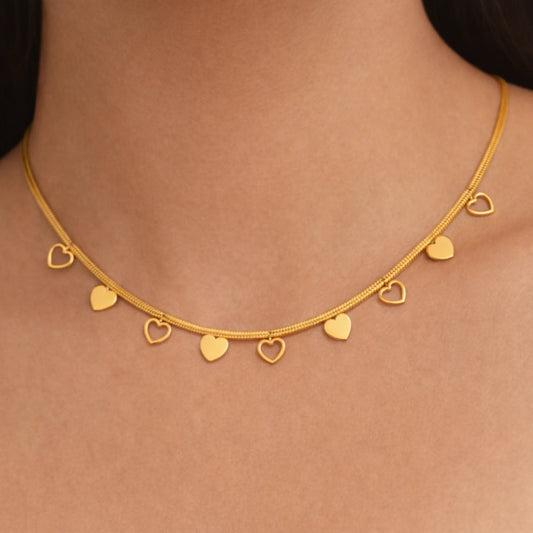 Gold necklace with heart-shaped pendants on a person's neck