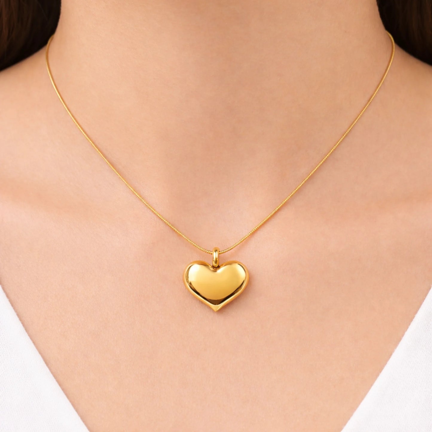 Gold heart-shaped necklace on a person's neck