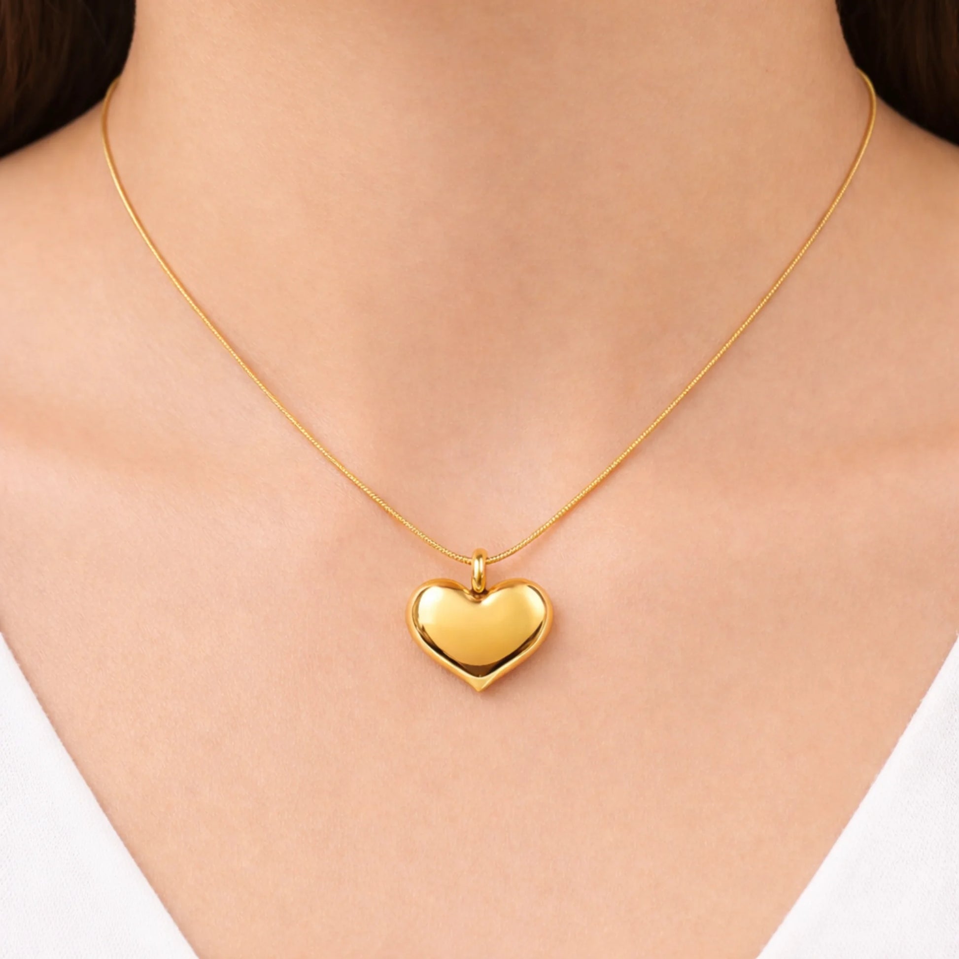 Gold heart-shaped necklace on a person's neck