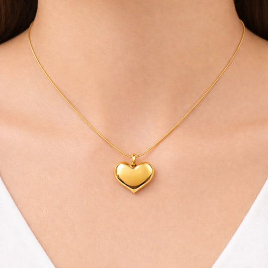 Gold heart-shaped necklace on a person's neck