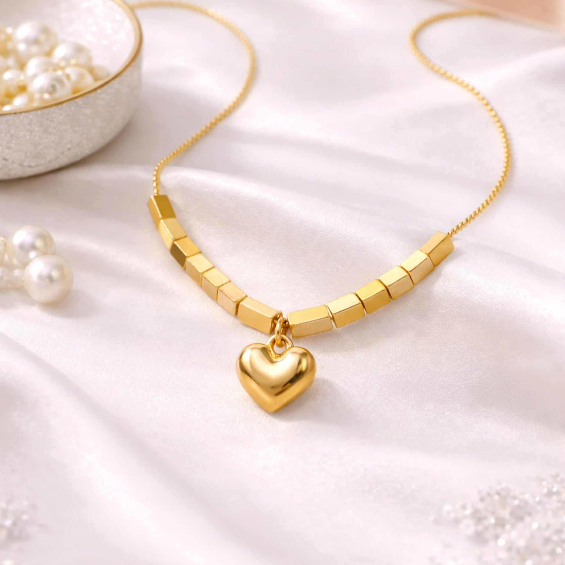 Gold necklace with a heart pendant on a white fabric background